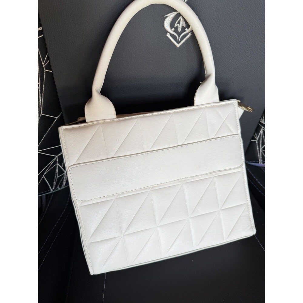 Geometric quilted white faux leather tote bag with black accents